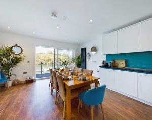 a kitchen and dining room with a table and chairs at 3 The Boatyard - Luxurious waterside 4 bed townhouse, lift, parking in Kingsbridge