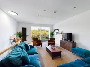 sala de estar con sofá azul y TV en 3 The Boatyard - Luxurious waterside 4 bed townhouse, lift, parking en Kingsbridge