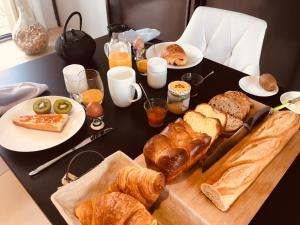 a table with bread and croissants and other breakfast foods at Le Clos n°5 in Villy-le-Moutier