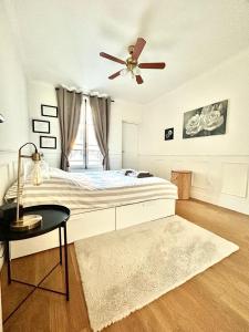 Schlafzimmer mit einem Bett und einem Deckenventilator in der Unterkunft Appartement proche de Roland-Garros in Boulogne-Billancourt