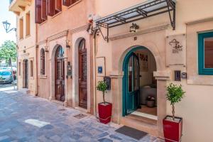 a building with two potted plants on a street at Boutique Hotel Fortino in Chania