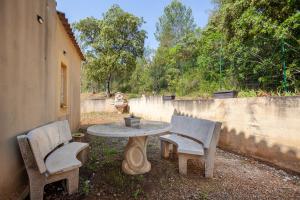 una mesa de hormigón con 2 sillas y una mesa con en Les collins du sud 2, en Peyrolles-en-Provence