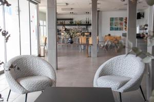 salon z 2 krzesłami i stołem w obiekcie Grupoandria Hotel Platja Gran w mieście Ciutadella