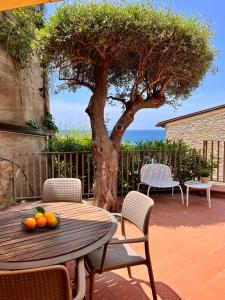 una mesa con un bol de fruta en ella delante de un árbol en Residenza Fontanelle-Beach Resort en Santa Maria di Castellabate
