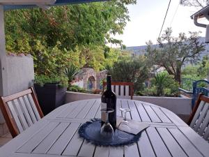 a bottle of wine sitting on top of a wooden table at Holiday Home Adricon in Grižane