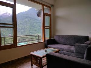 a living room with a couch and a table at Cabin in the Woods in Vashisht