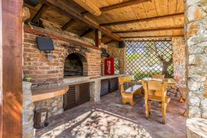 an outdoor patio with a brick fireplace and a table at Holiday Home OLIVE GARDEN in Brzac