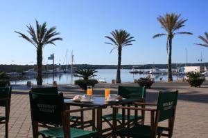 a table and chairs with a view of a marina at Hostal S'Algaret in Fornells