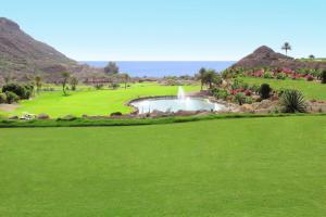 a golf course with a pond and a fountain at Luxury Villa Lucia in La Playa de Tauro