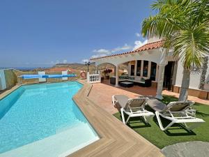 La Playa de TauroにあるLuxury Villa Luciaのスイミングプール(椅子2脚付)と家