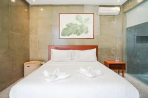 una camera da letto con un letto bianco con due archi bianchi di Aqilah Villa Bali a Legian