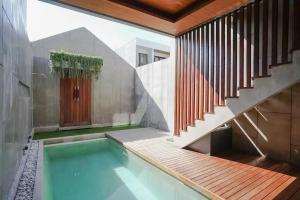 a house with a swimming pool and a staircase at Aqilah Villa Bali in Legian