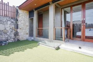 a house with a large glass door and a balcony at Aqilah Villa Bali in Legian