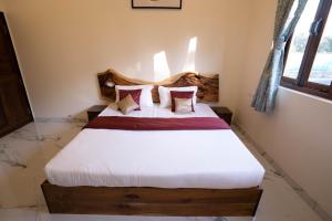 una camera da letto con letto, lenzuola e cuscini bianchi di West Valley Villa Casa Vista a Avas