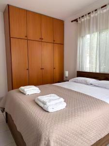een slaapkamer met 2 bedden, houten kasten en witte handdoeken bij The Serenity Bungalow in Anarita