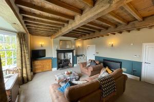 uma sala de estar com dois sofás e uma televisão em Woodpecker Cottage em West Bretton