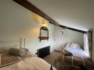 Un dormitorio con dos camas y una ventana. en Woodpecker Cottage, en West Bretton