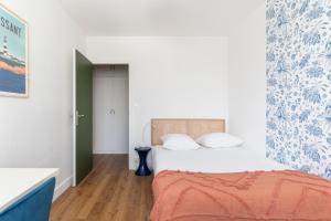 a bedroom with a bed with a orange blanket at Joli Appartement avec Garage sur l'Île de Nantes in Nantes