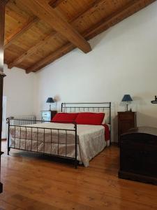 Il Monte BnB في Tazzola: غرفة نوم بسرير وسقف خشبي