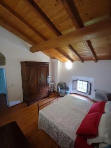 Il Monte BnB في Tazzola: غرفة نوم بسرير كبير وسقف خشبي