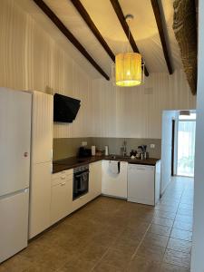 uma cozinha com electrodomésticos brancos e um lustre em Primera Linea de Playa, Villa Conchita, con Salida al Mar em Sagunto