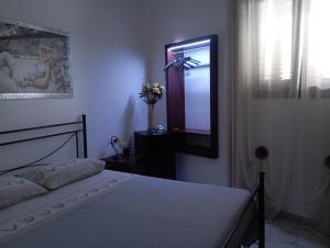 - une chambre avec un lit et un miroir mural dans l'établissement B&B Lo Scrigno del Salento, à Sava