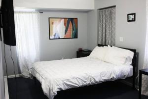 ein Schlafzimmer mit einem großen Bett mit weißer Bettwäsche in der Unterkunft Spacious Cozy 2 Bedroom - Near EWR/NYC/OUTLET MALL in Newark