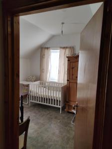 a baby room with a crib and a window at Lovely 4-bed property in Mullaghbawn in Meigh
