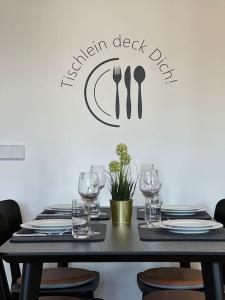 a black table with glasses and a sign that reads garden desk dip at Goethe Palais Suite Zauberlehrling 4P l Lift l Parkplatz I Zentrum I Helios in Aue
