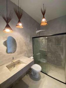 uma casa de banho com um lavatório, um WC e 2 luzes em 4 quartos ao lado da praia do Patacho em Porto de Pedras