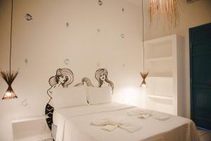 a bedroom with a bed with a drawing on the wall at 4 quartos ao lado da praia do Patacho in Pôrto de Pedras