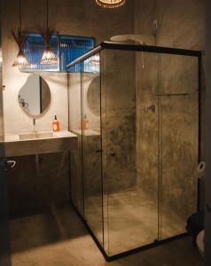 a shower in a bathroom with a sink and a mirror at 4 quartos ao lado da praia do Patacho in Pôrto de Pedras