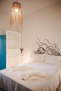 a bedroom with a white bed with a branch headboard at 4 quartos ao lado da praia do Patacho in Pôrto de Pedras