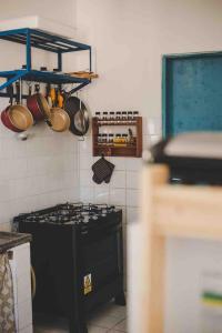 a kitchen with a black stove and utensils at 4 quartos ao lado da praia do Patacho in Pôrto de Pedras +46 photos