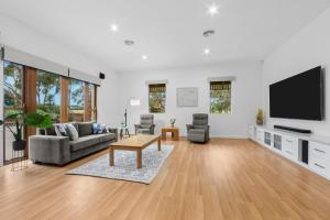 a living room with a couch and a tv at Escape farmhouse with cow birds lakes-SP group in Leopold