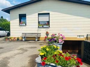 a house with flowers in front of a bench at Apartment Menesa 