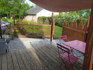a wooden deck with a pink table and chairs at Au coeur des Rias, studio Merrien proche de la mer in Moëlan-sur-Mer +3 photos