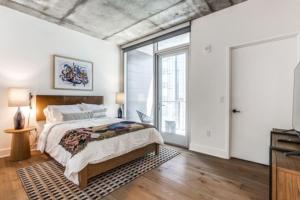 1 dormitorio con cama y ventana grande en 2 BR Lux Panoramic View - Rainey, en Austin
