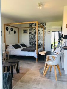 オンフルールにあるBel Air Studios-Terrasse couverte-Jardinet-Vue Pont de Normandie-Parking privéのベッドルーム1室(ベッド1台、テーブル、椅子付)