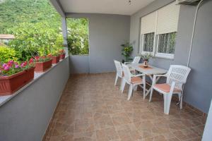 a balcony with a table and chairs and flowers at Apartment Hercegovina in Mostar