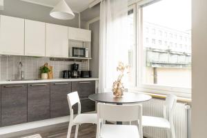 cocina con mesa, sillas y ventana en Spacious 2br Apartment in the City Center, en Tampere