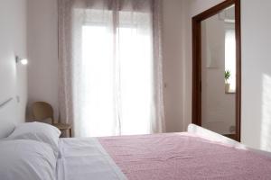 - une chambre avec un lit blanc et une fenêtre dans l'établissement App.Carrera Fondi, à Fondi