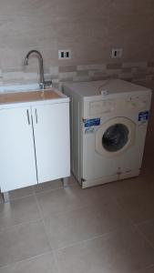 een wasmachine en een wastafel in de kamer bij casa rosa in Tiggiano