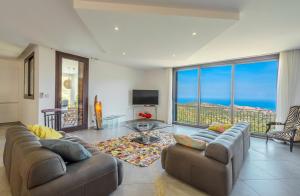 a living room with two couches and a view of the ocean at Domaine Bagia Donne in Santa-Reparata-di-Balagna