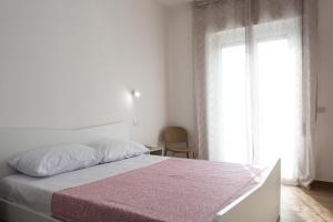 - une chambre blanche avec un lit et une fenêtre dans l'établissement App.Carrera Fondi, à Fondi