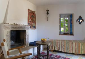 a living room with a fireplace and a bed at Phlea Farm Studios in Alinda