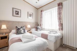 Habitación con 2 camas y ventana en Stewarts Resort Lodge 52 en St Andrews