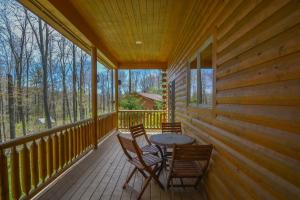 a wooden porch with a table and chairs on it at Donovans Dacha in McHenry