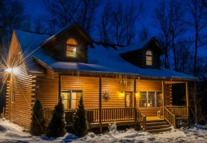 una cabaña de madera en la nieve por la noche en Donovans Dacha, en McHenry