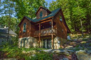 a large wooden house with a balcony in the woods at Hidden Treasure in Oakland